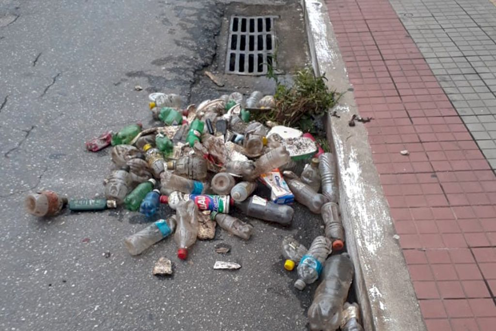 Foto mostra descarte de garrafas pet em bueiro do centro da cidade